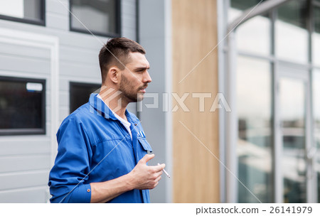 auto mechanic smoking cigarette at car workshop 26141979