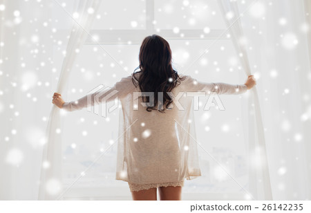 close up of happy woman opening window curtains 26142235