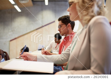 group of students with notebooks in lecture hall 26143001