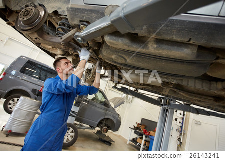 mechanic man or smith repairing car at workshop 26143241