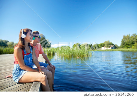 happy teenage couple with earphones on river berth happy teenage couple with earphones on river berth 26143260