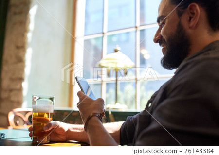 close up of man with smartphone and beer at pub 26143384