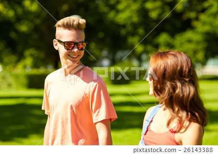 happy teenage couple walking at summer park 26143388