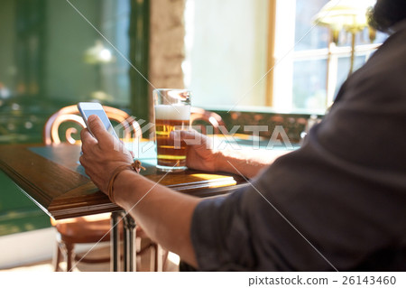 close up of man with smartphone and beer at pub 26143460