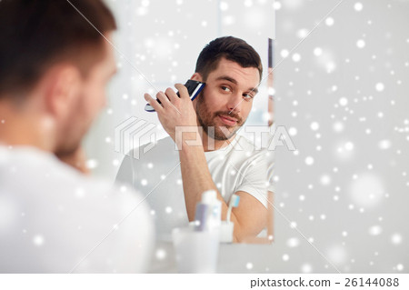 man shaving beard with trimmer at bathroom 26144088