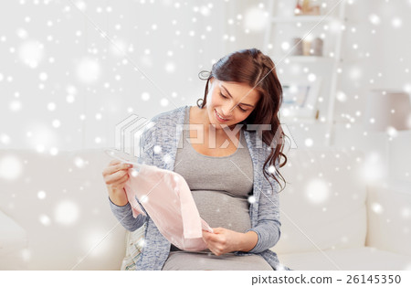 happy woman holding baby girls bodysuit at home 26145350