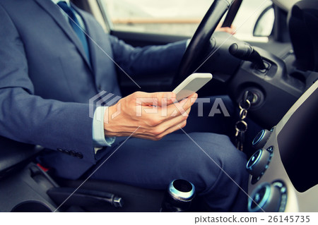 close up of man with smartphone driving car close up of man with smartphone driving car 26145735