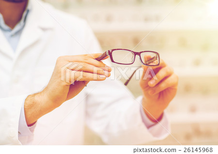 close up of optician with glasses at optics store 26145968