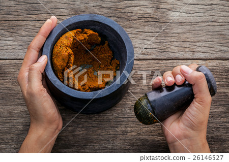 The women hold pestle with mortar . The women hold pestle with mortar . 26146527