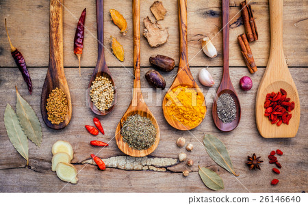 Various herbs and spices in wooden spoons.  26146640