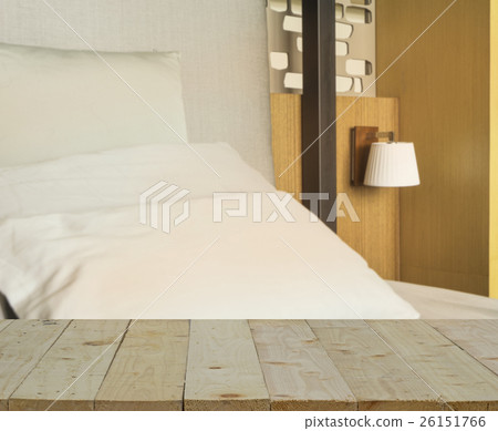 wood table top on blur of bedroom and pillows  26151766