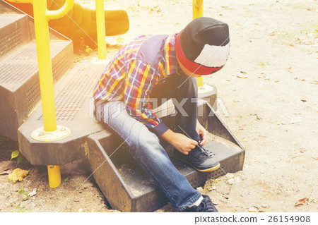 Child tying shoes in the playground.Zoom in Child tying shoes in the playground.Zoom in 26154908