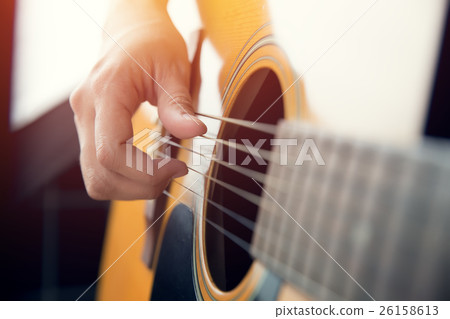 Female hand playing on acoustic guitar 26158613