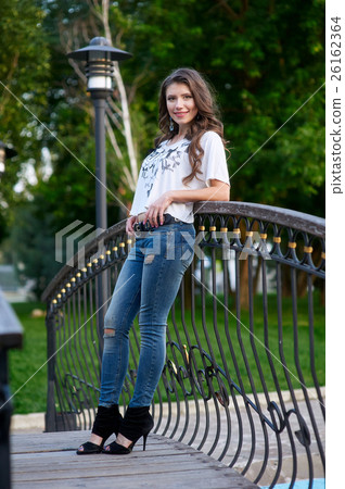 young woman standing on the bridge in jeans and a 26162364