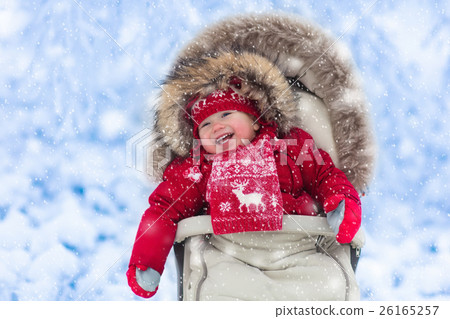 Baby in stroller in winter park with snow 26165257