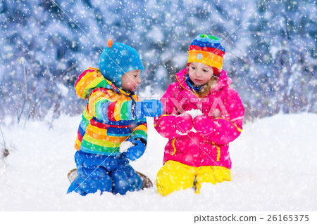 Children playing in snowy winter park 26165375