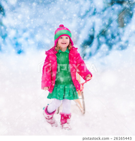 Little girl playing in snowy winter forest 26165443