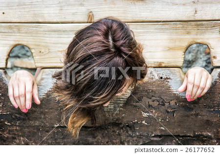 Young caucasian woman in medieval pillory 26177652