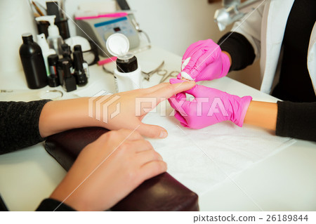 Manicure specialist prepares hands. 26189844