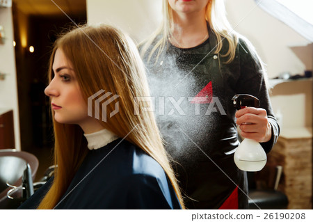 Woman hairdresser uses spray for hair Woman hairdresser uses spray for hair 26190208