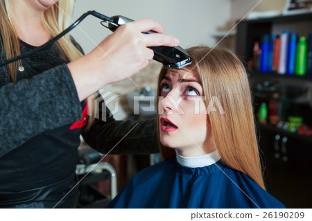 Young female afraid the machine for hair. Young female afraid the machine for hair. 26190209