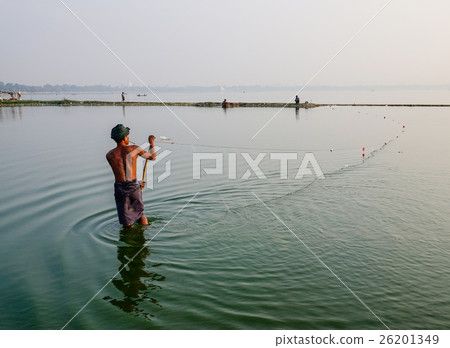 Burmese man catching fish on lake Burmese man catching fish on lake 26201349