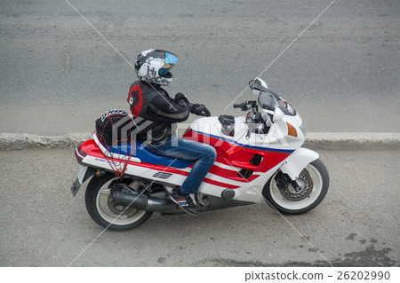 Biker in a helmet sitting on his motorcycle. Biker in a helmet sitting on his motorcycle. 26202990