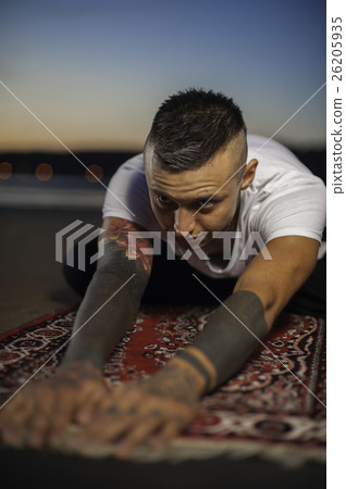 Young man doing yoga on the beach at sunset Young man doing yoga on the beach at sunset 26205935