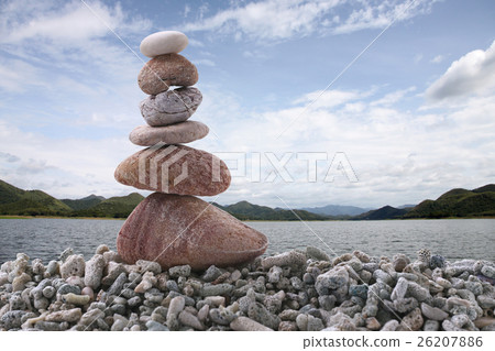 Balance stone on pile rock with river background. Balance stone on pile rock with river background. 26207886