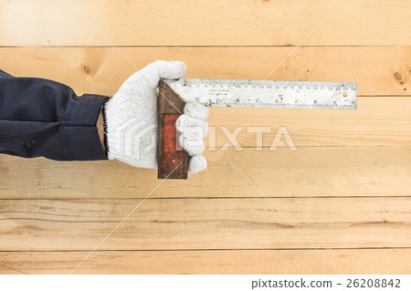 Hand in glove holding iron ruler Hand in glove holding iron ruler 26208842