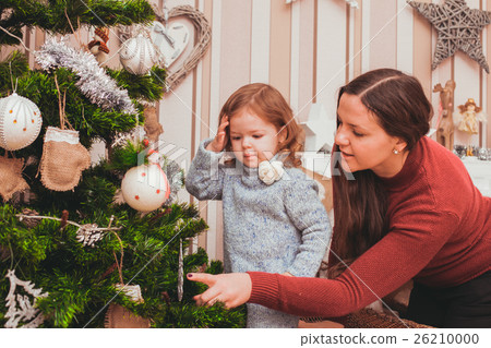 Mom and daughter decorating Christmas tree 26210000