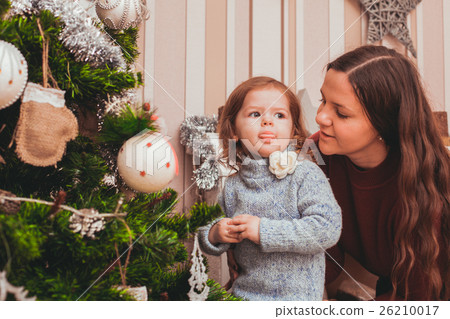 Mom and daughter decorating Christmas tree Mom and daughter decorating Christmas tree 26210017