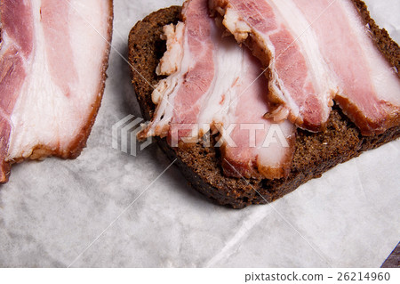 Slices of smoked bacon with rye black bread Slices of smoked bacon with rye black bread 26214960