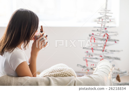 Young beautiful woman drinking hot chocolate with marshmallow in Young beautiful woman drinking hot chocolate with marshmallow in 26218834