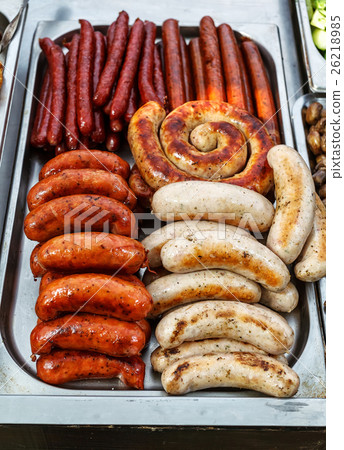 Assorted sausages grilled in a steel container 26218985