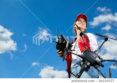 Woman is standing and holding drone Woman is standing and holding drone 26220527