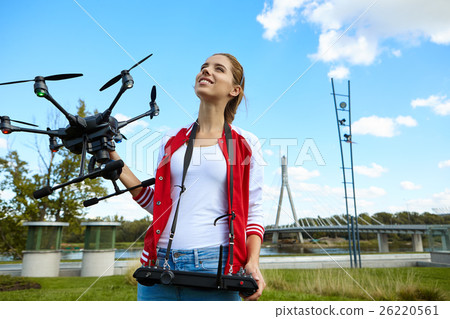 Woman is standing and holding drone Woman is standing and holding drone 26220561