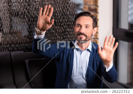 Delighted bearded man pressing his palms to the Delighted bearded man pressing his palms to the 26222352