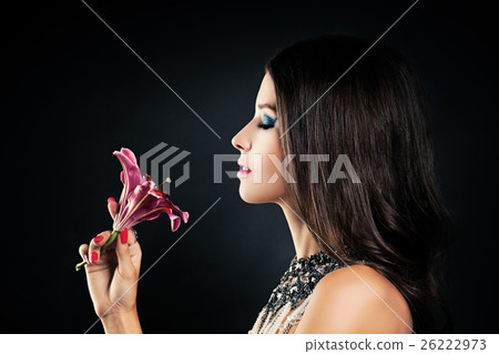 Woman Smelling a Flower Lily on a Dark Background Woman Smelling a Flower Lily on a Dark Background 26222973