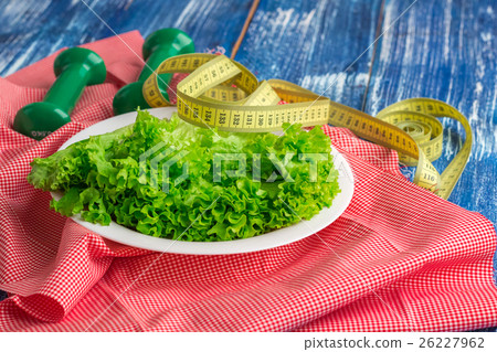 Fitness food, lettuce on plate, weights and ruler Fitness food, lettuce on plate, weights and ruler 26227962