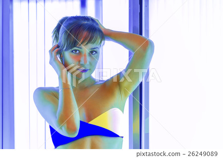Slim woman in solarium getting sun tan 26249089