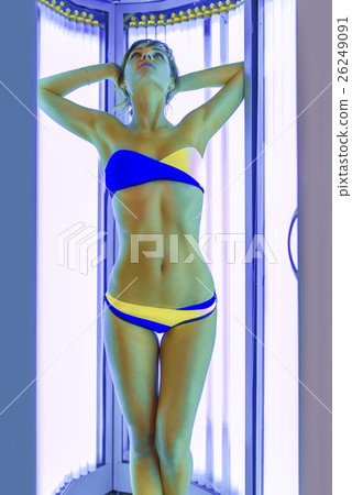 Slim woman in solarium getting sun tan 26249091