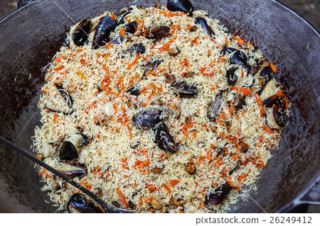 Cooking pilaf with mussels dish in a cauldron 26249412