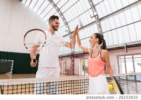 Positive tennis players giving high five Positive tennis players giving high five 26253810