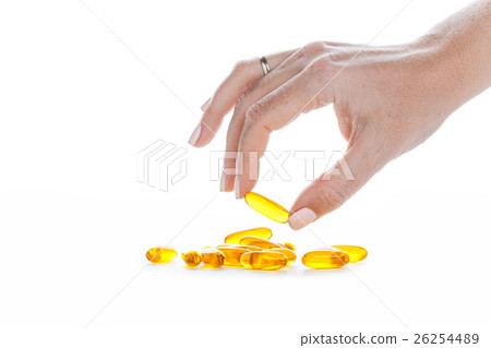 Soft gels pills with Omega-3 oil in fingers Soft gels pills with Omega-3 oil in fingers 26254489