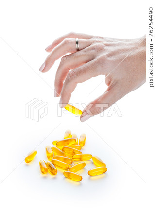 Soft gels pills with Omega-3 oil in fingers Soft gels pills with Omega-3 oil in fingers 26254490