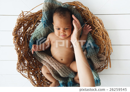 Top view on biracial baby in wicker cradle Top view on biracial baby in wicker cradle 26259545