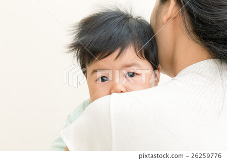 Asian baby sick and unhappy on mom shoulder. Asian baby sick and unhappy on mom shoulder. 26259776