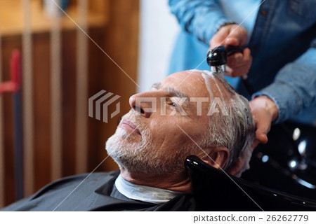 Old man during washing his hair in barber shop 26262779
