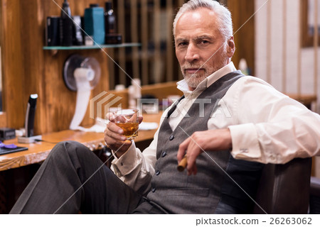 Man sitting with cognac glass and cigar Man sitting with cognac glass and cigar 26263062